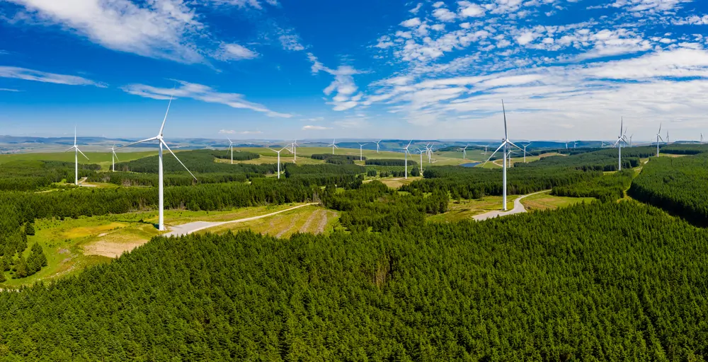Aerial photo of wind turbines surrounded by woods in Wales, UK
